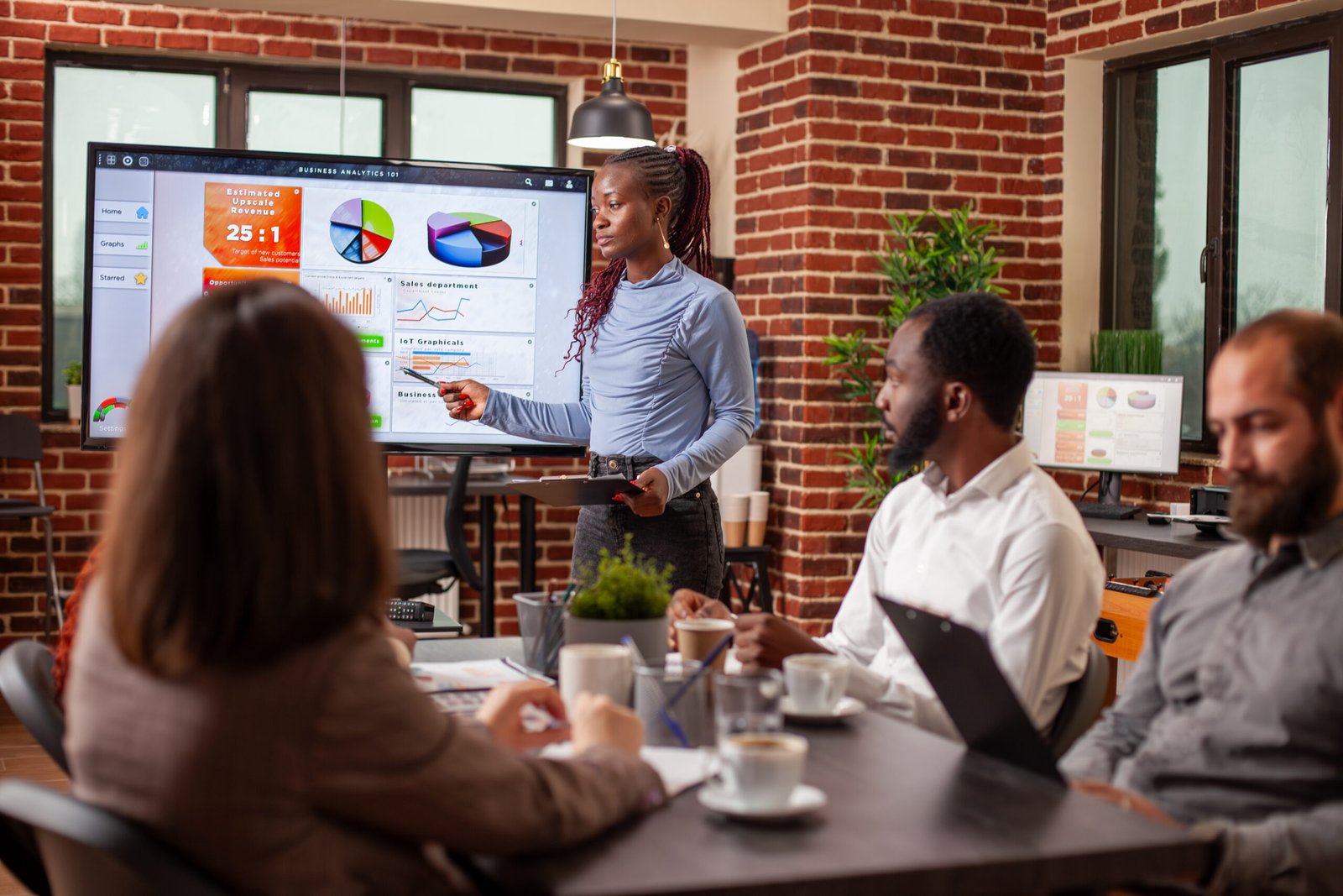 L'équipe de GC PRO Consulting anime une réunion en expliquant des idées stratégiques à l'aide d'un écran numérique.